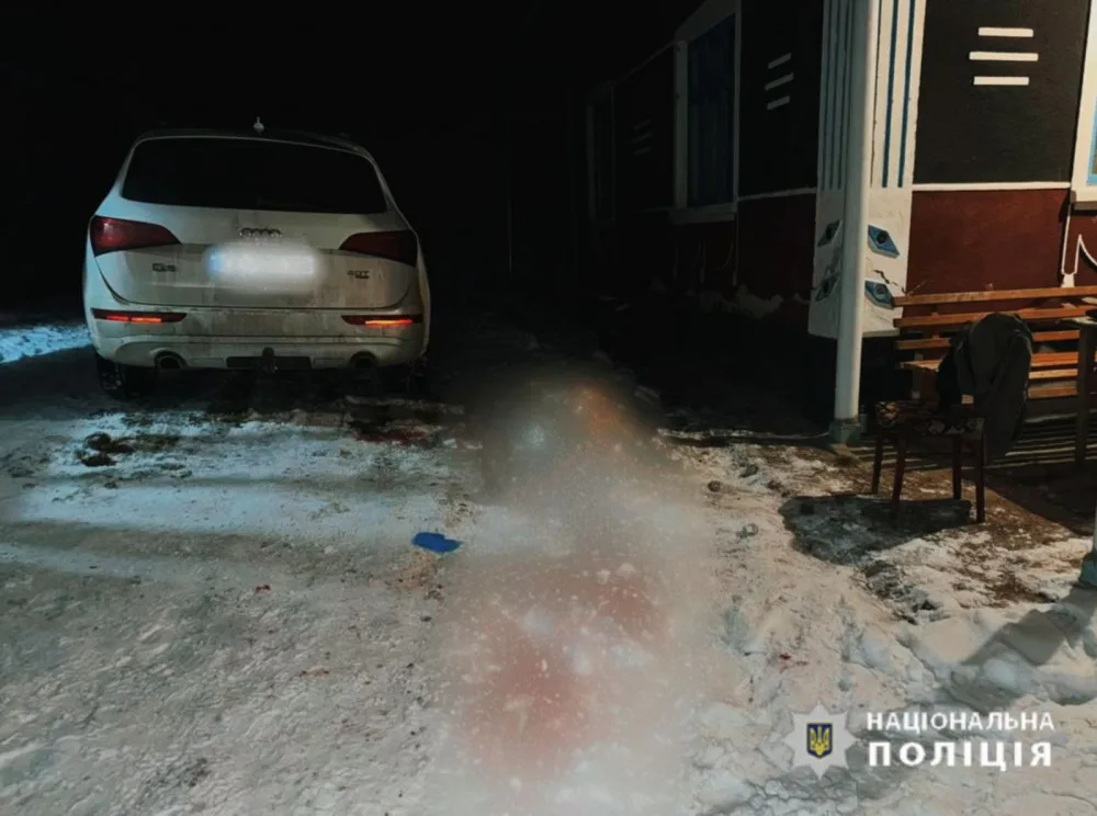 Поліцейське фото засніженого подвір’я з автомобілем і заблюреним тілом