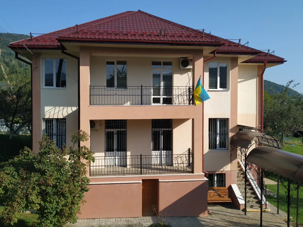 Будинок із червоним дахом та українським прапором