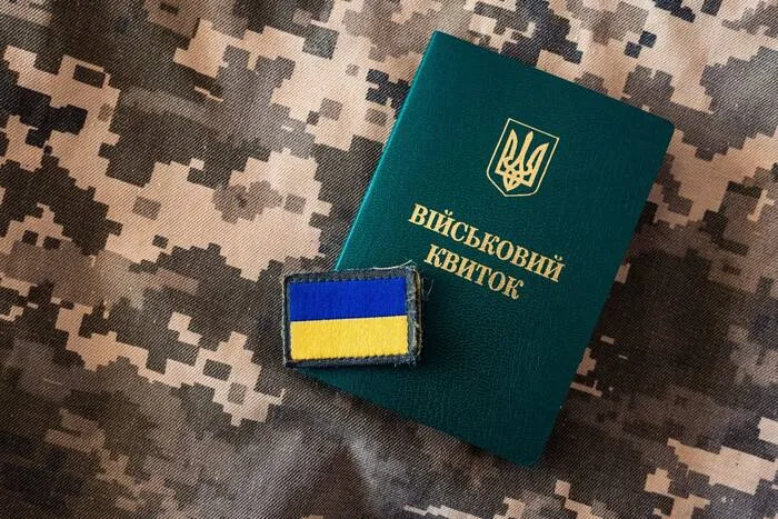 Військовий квиток України та нашивка прапора на камуфляжі