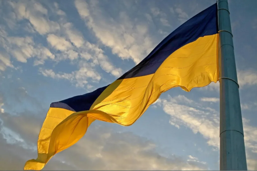 Український прапор майорить на тлі хмарного неба