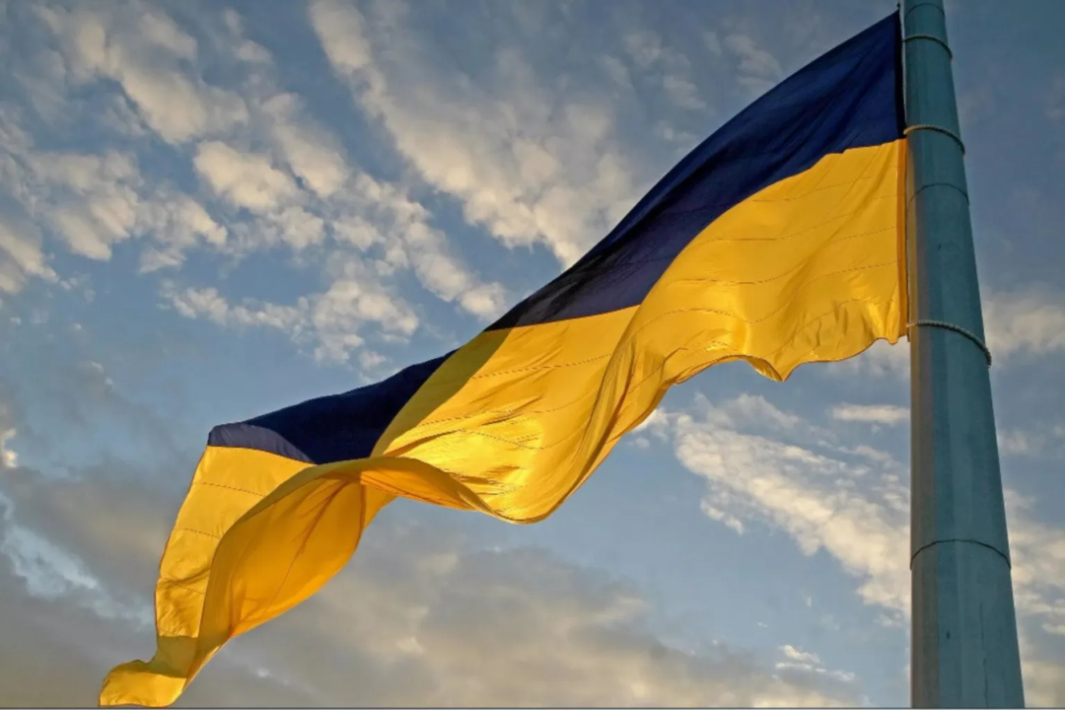 Український прапор майорить на тлі хмарного неба