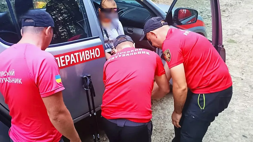 Рятувальники допомагають людині біля службового автомобіля