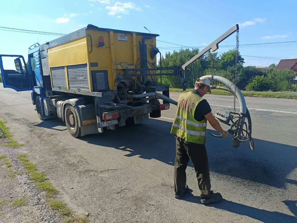 Працівник керує дорожньою машиною для ямкового ремонту