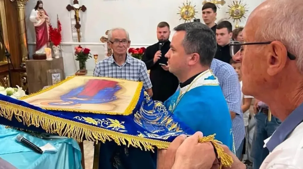 Священник несе прикрашену ікону під час богослужіння