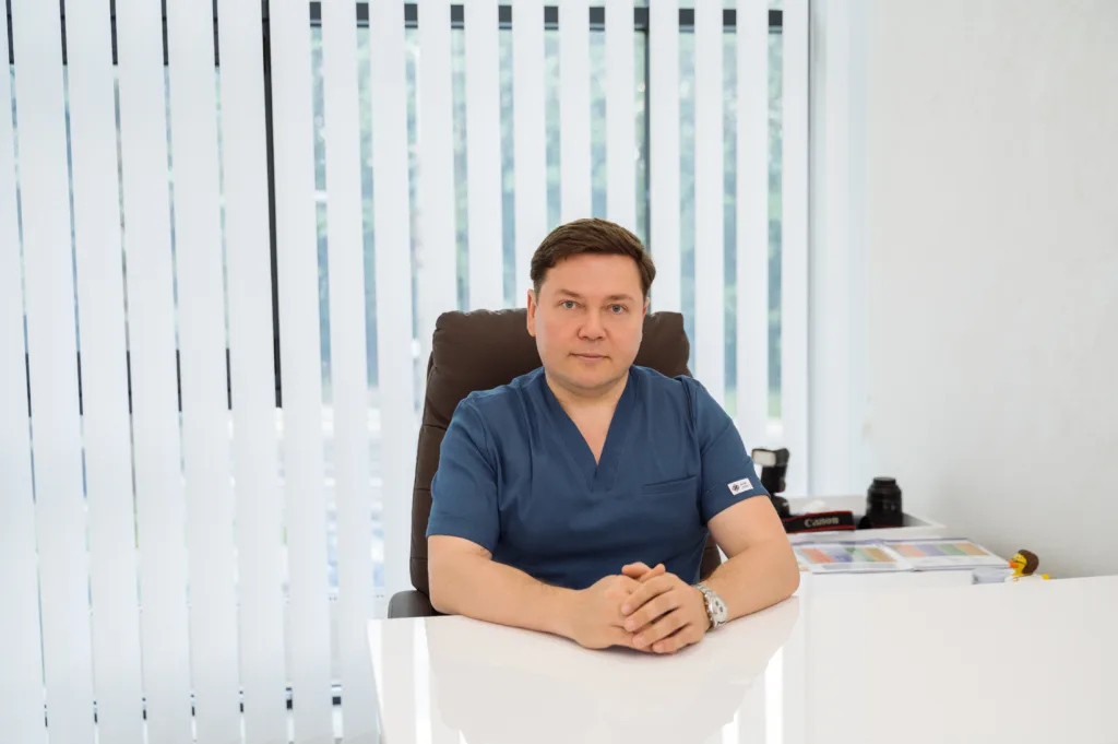 Чоловік у медичній формі сидить за столом