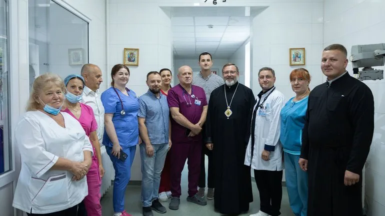 Медики та священнослужителі у лікарняному коридорі