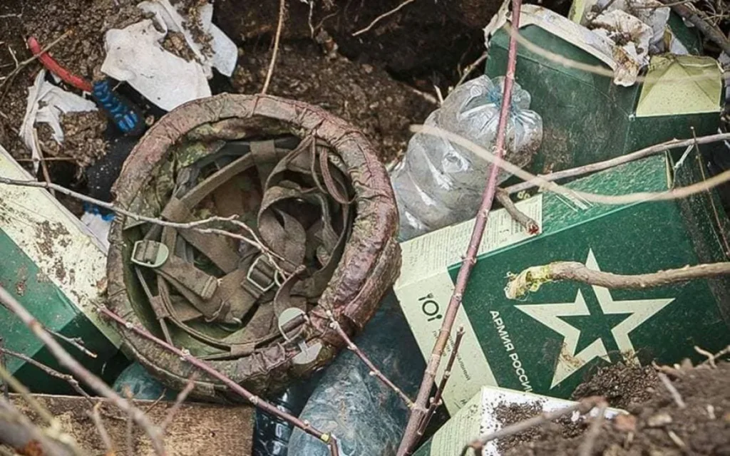 Закривавлена каска серед російських військових пайків у землі