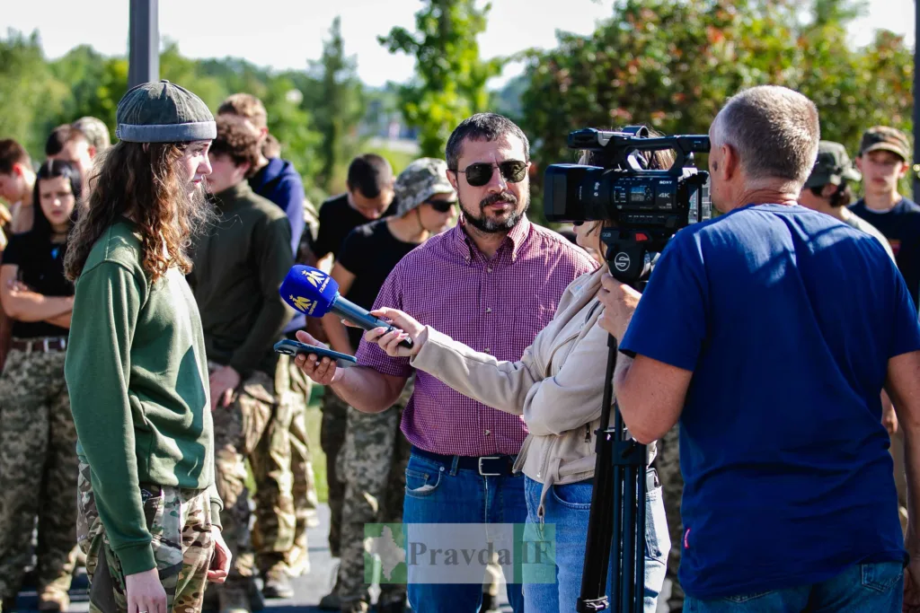 Журналісти беруть інтерв’ю у військової на вулиці