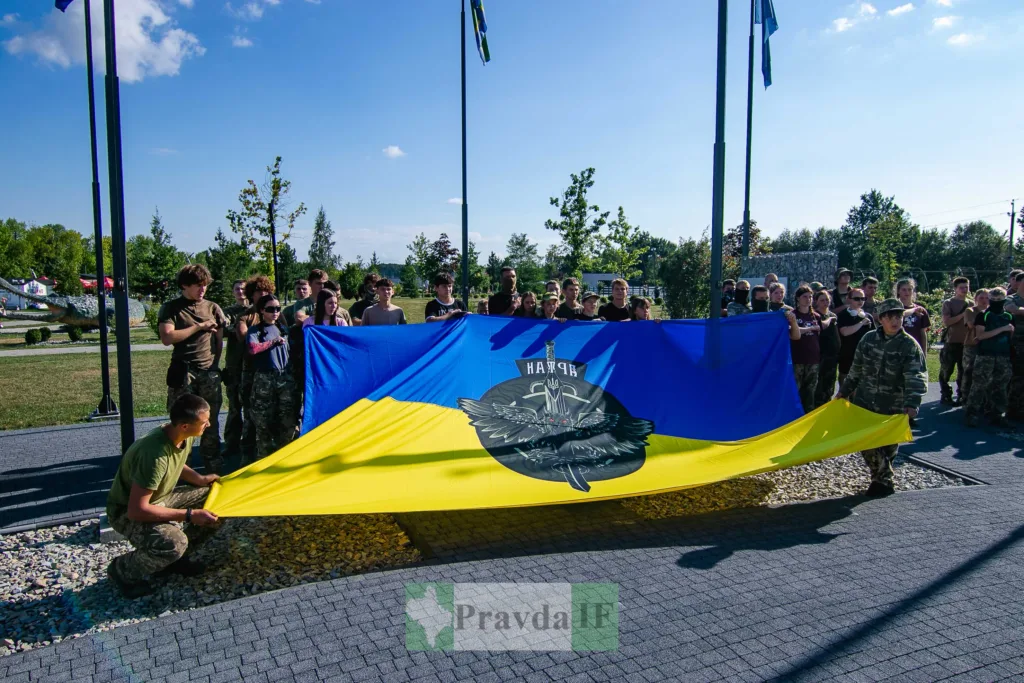 Люди тримають прапор із емблемою Нацгвардії України