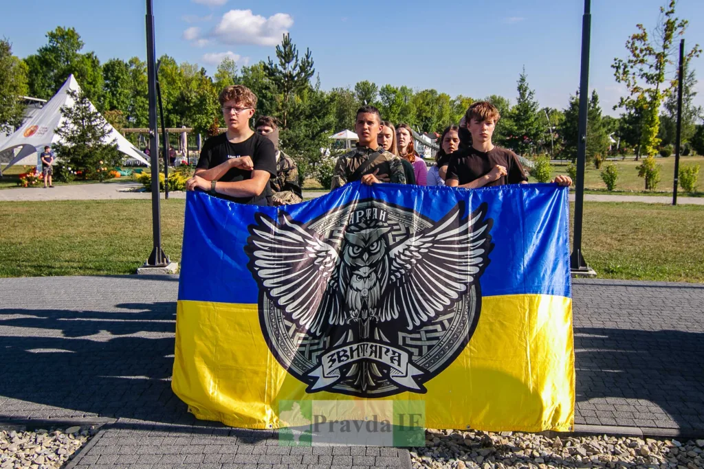 Молодь тримає український прапор із символікою «Звитяги»