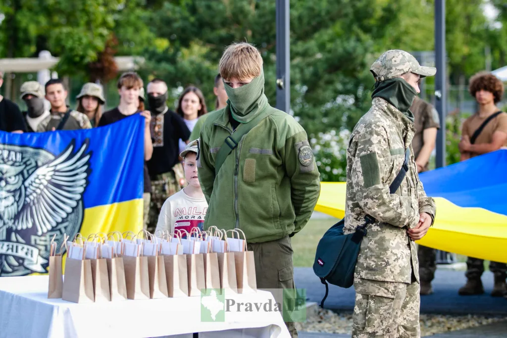 Військові обіймаються біля українських прапорів і подарунків