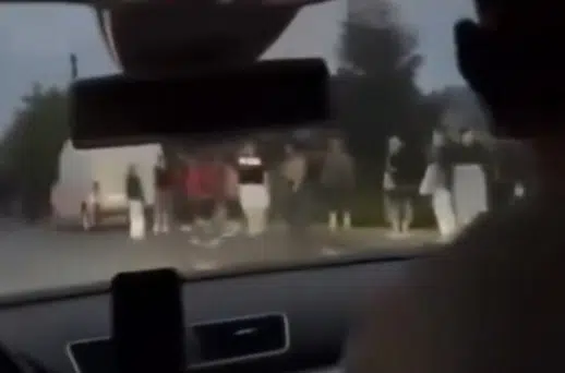 Люди стоять біля дороги, видно з салону автомобіля