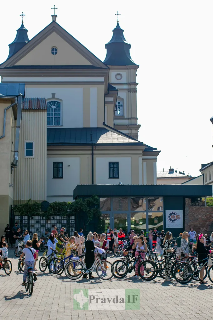 Люди з велосипедами біля храму