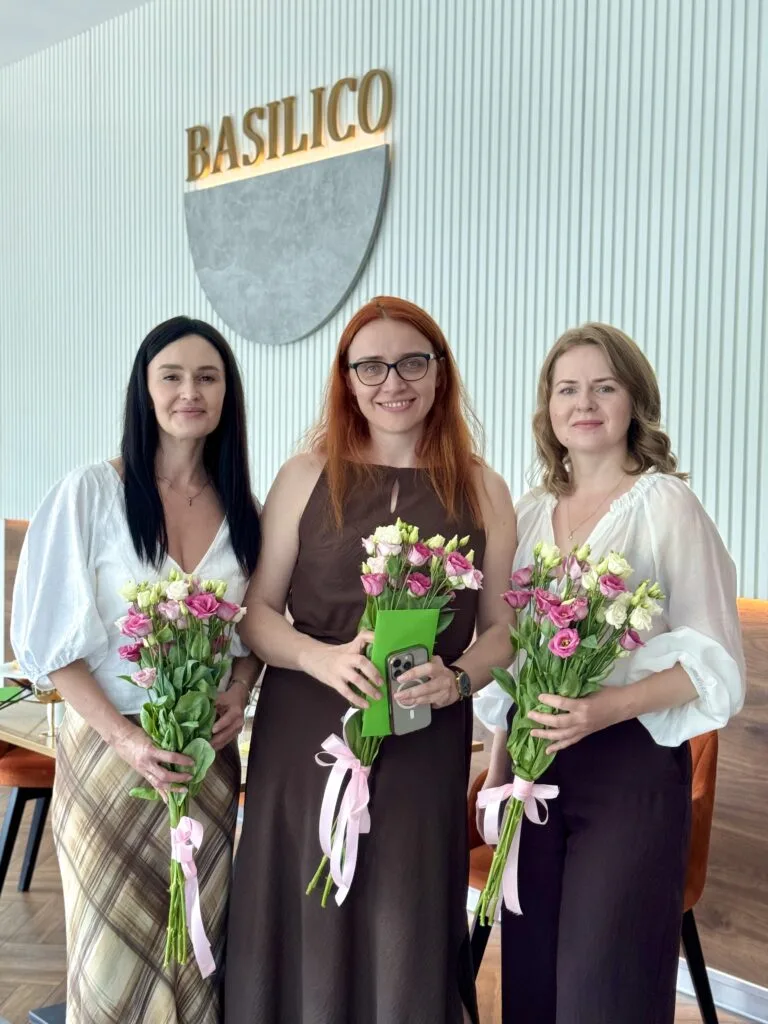 Троє жінок із букетами квітів у ресторані Basilico