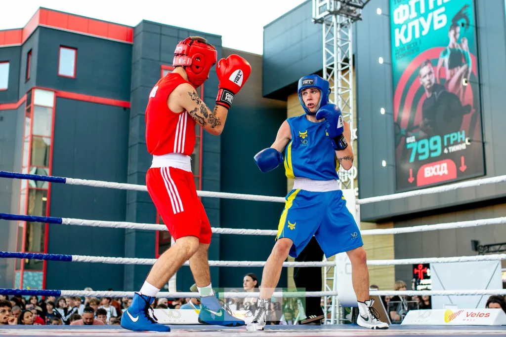 Боксери в червоній і синій формі на рингу
