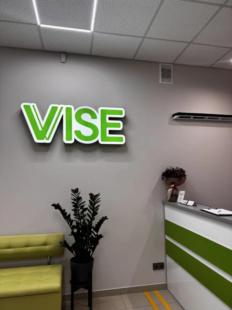 Ресепшн клініки VISE із зеленим логотипом