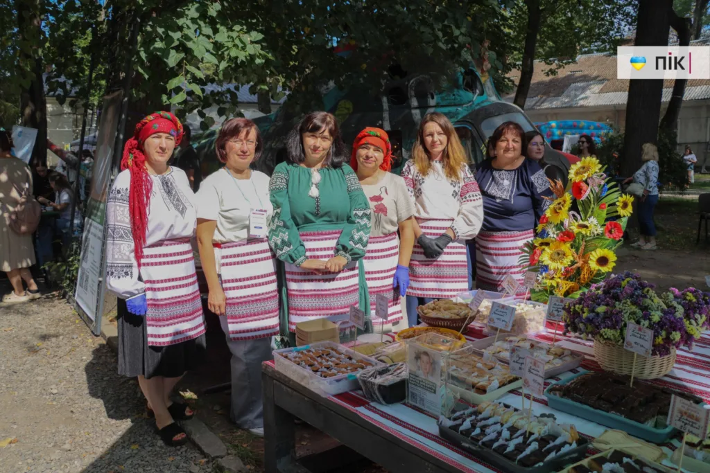 Жінки у вишиванках біля столу з українськими солодощами