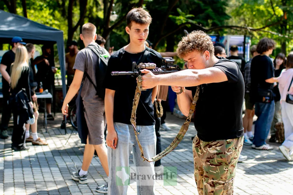 Юнак прицілюється з гвинтівки на вуличному заході