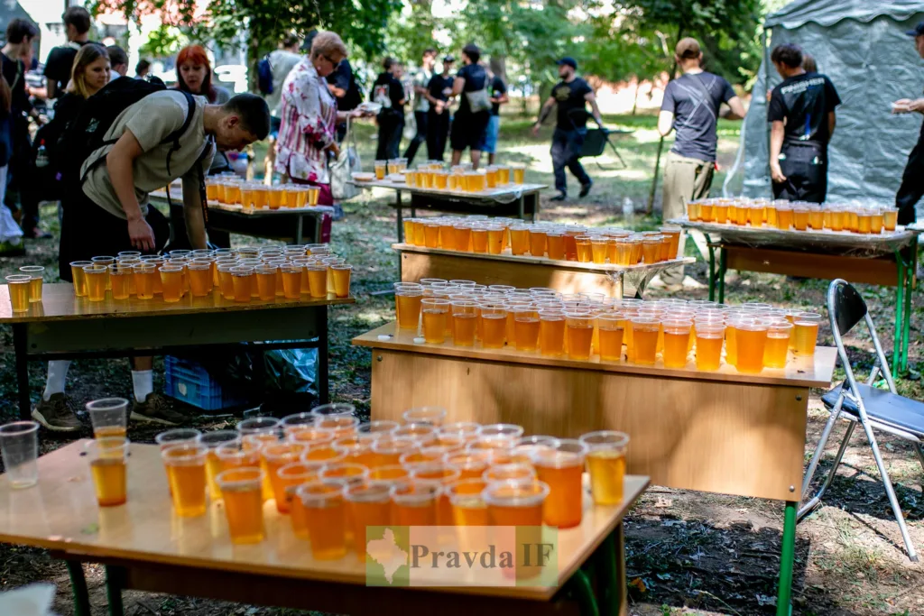 Столи з пластиковими стаканами напою на вуличному заході