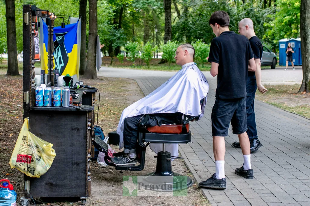 Вуличний барбер стриже чоловіка в парку