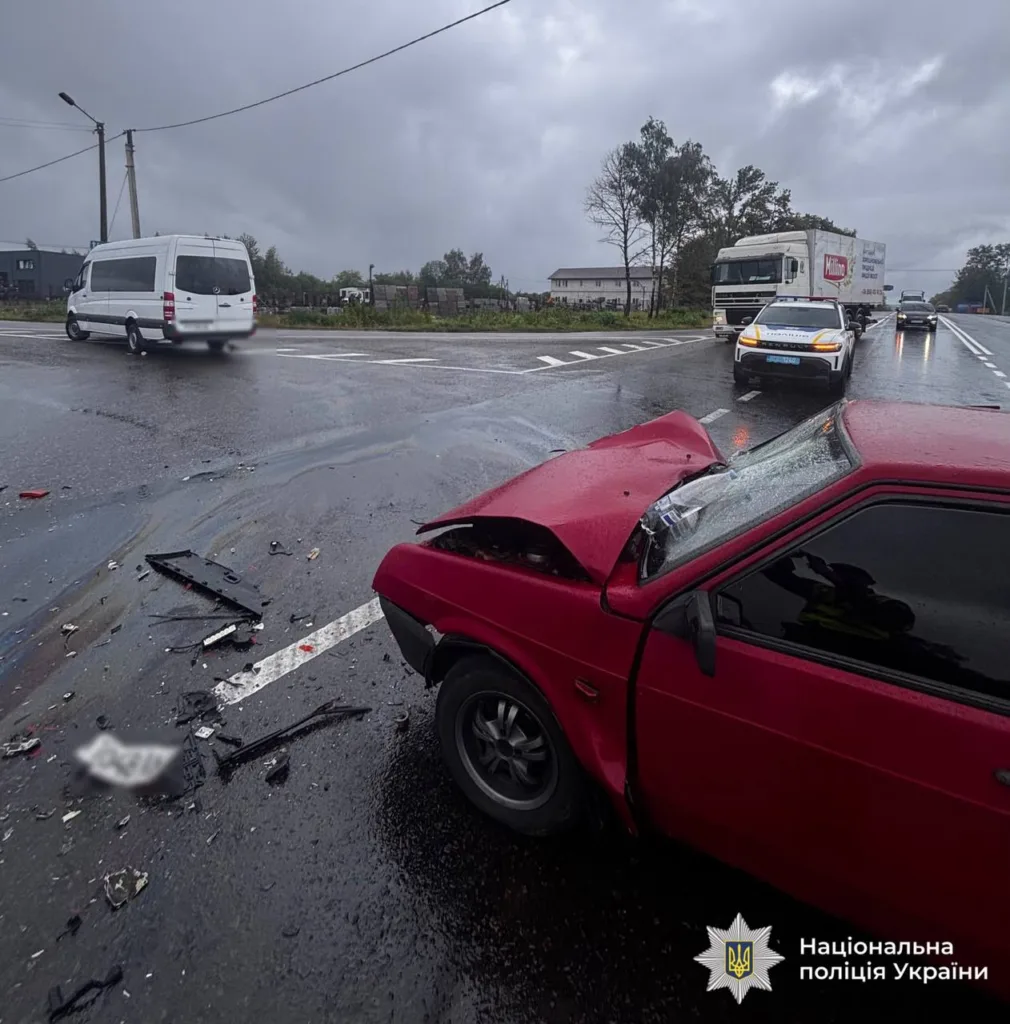 Пошкоджений червоний автомобіль після ДТП на мокрій трасі