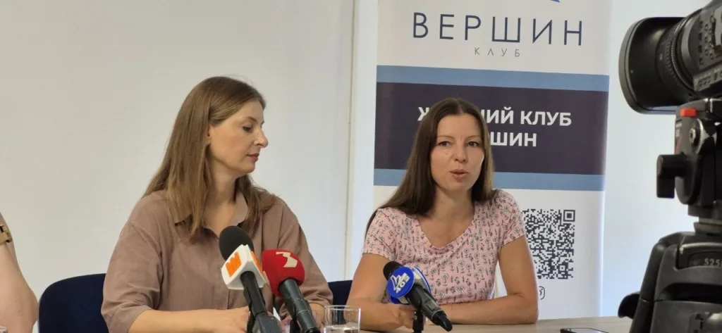 Дві жінки на пресконференції перед мікрофонами
