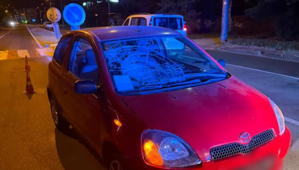 Червоне авто з розбитим лобовим склом уночі