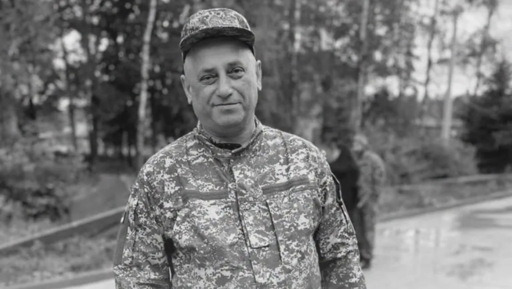 Військовий у камуфляжі стоїть на тлі дерев