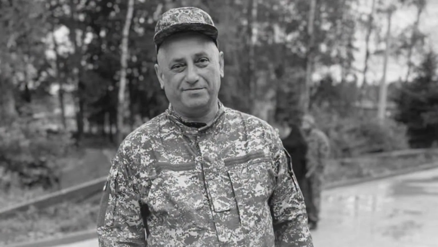 Військовий у камуфляжі стоїть на тлі дерев