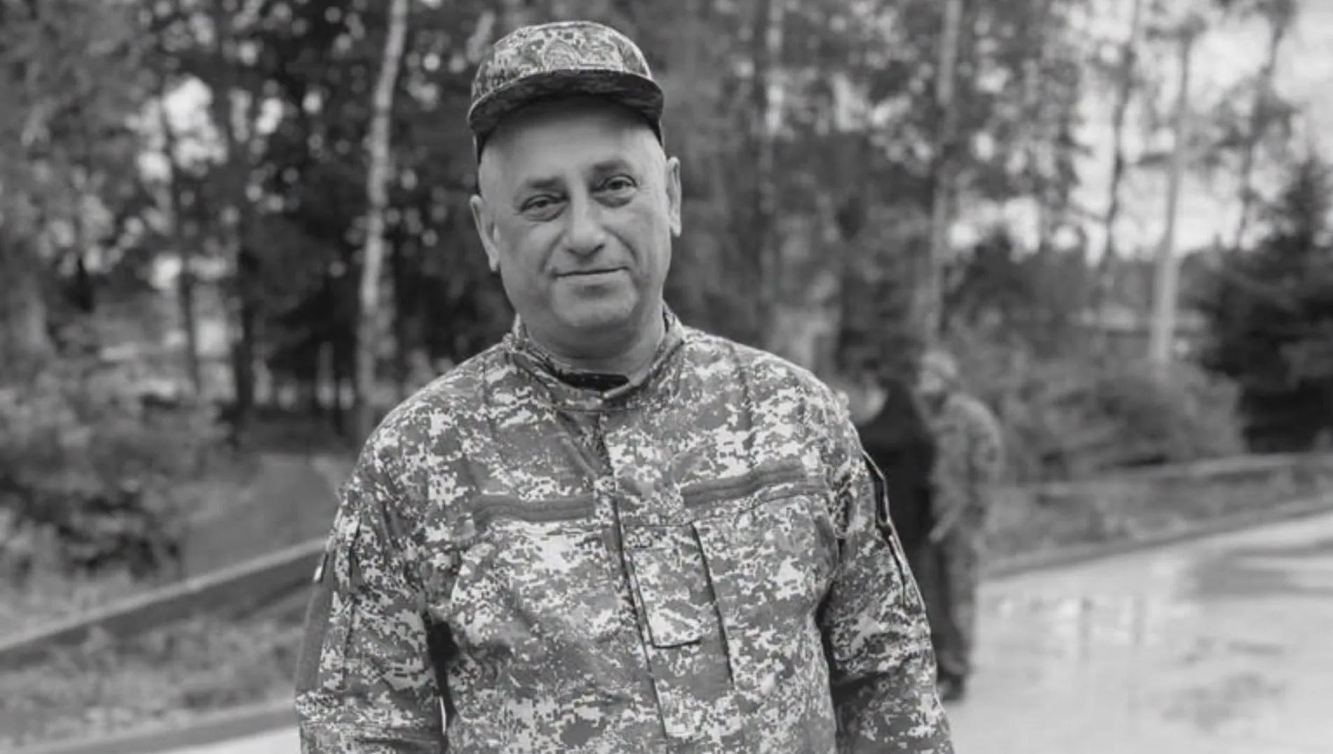 Військовий у камуфляжі стоїть на тлі дерев