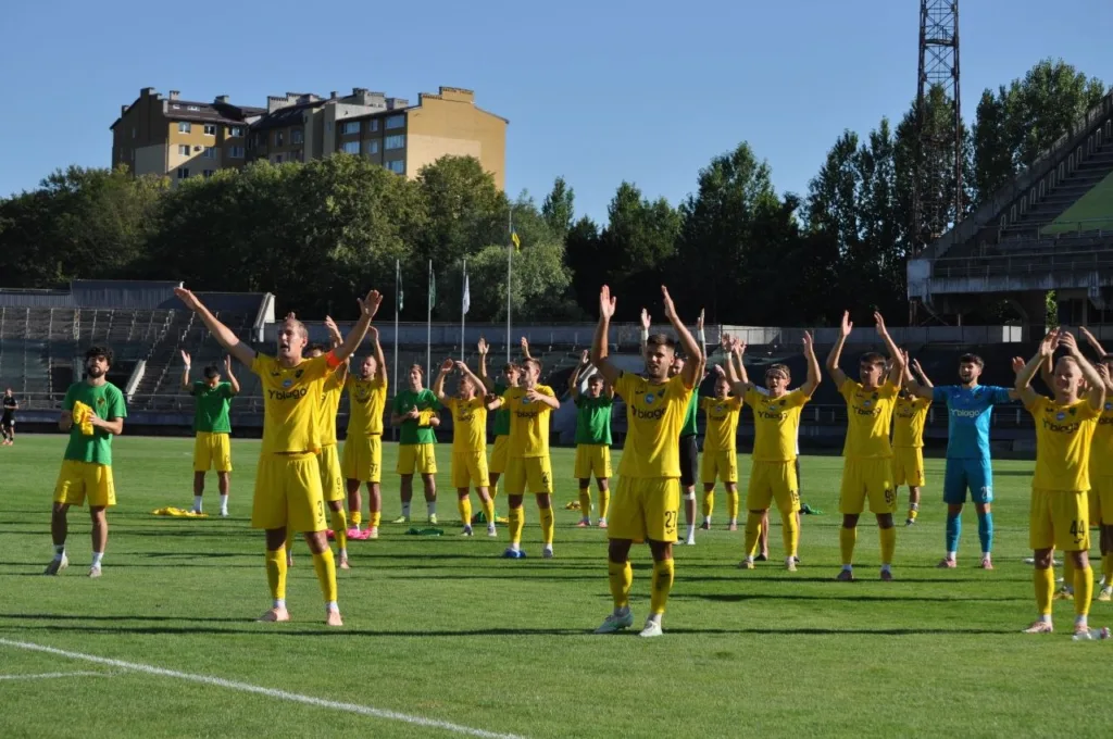 Футболісти в жовтій формі вітають уболівальників на полі