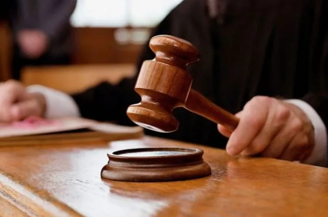 Суддя тримає дерев’яний молоток над підставкою