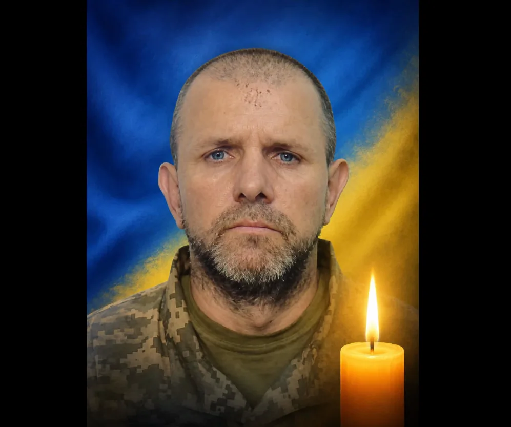 Портрет військового на тлі прапора України зі свічкою