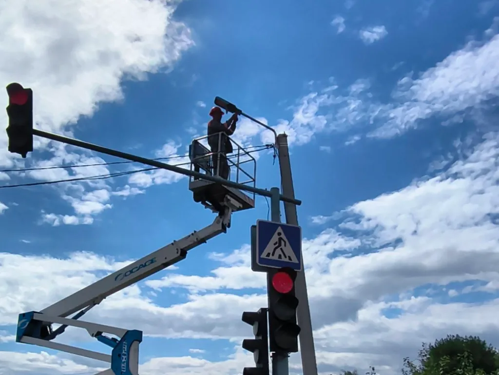 Працівник ремонтує світлофор з автовишки