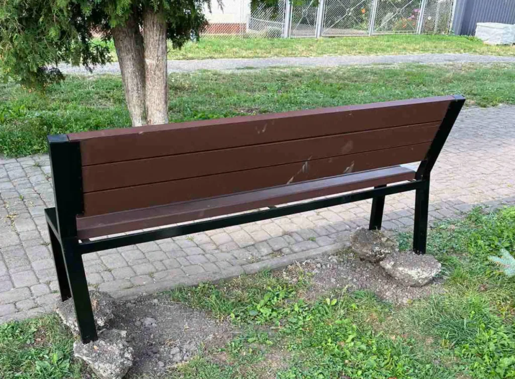 Коричнева лавка в парку біля дерева