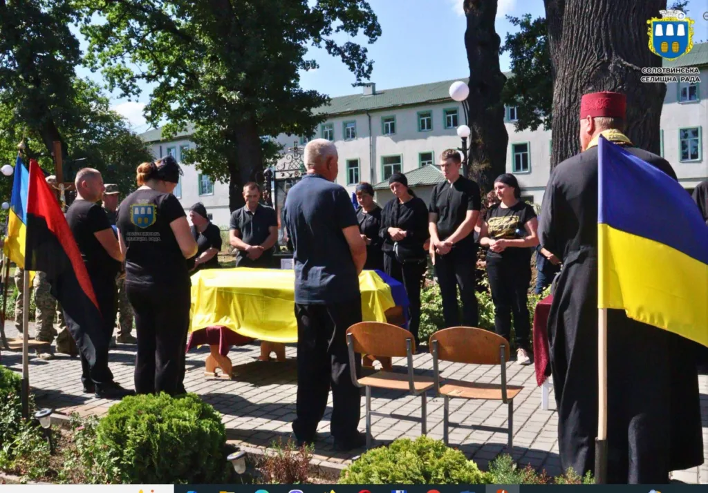 Церемонія прощання з загиблим військовим під українським прапором