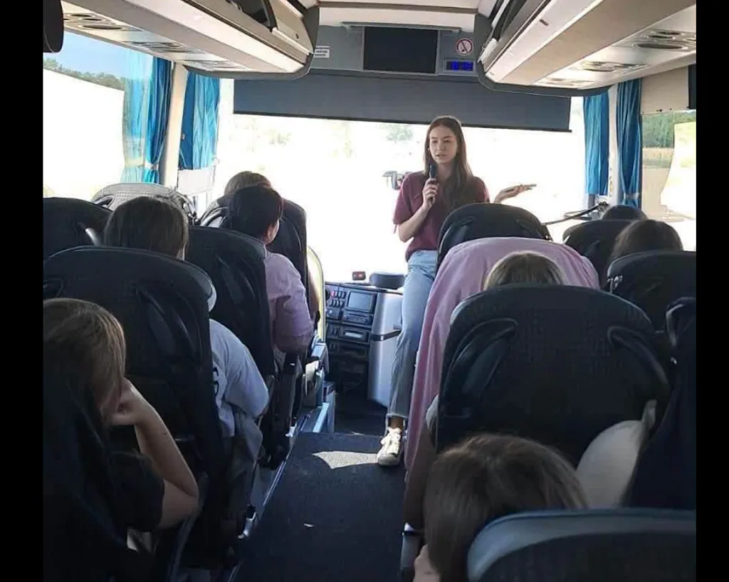 Екскурсоводка розповідає пасажирам у туристичному автобусі