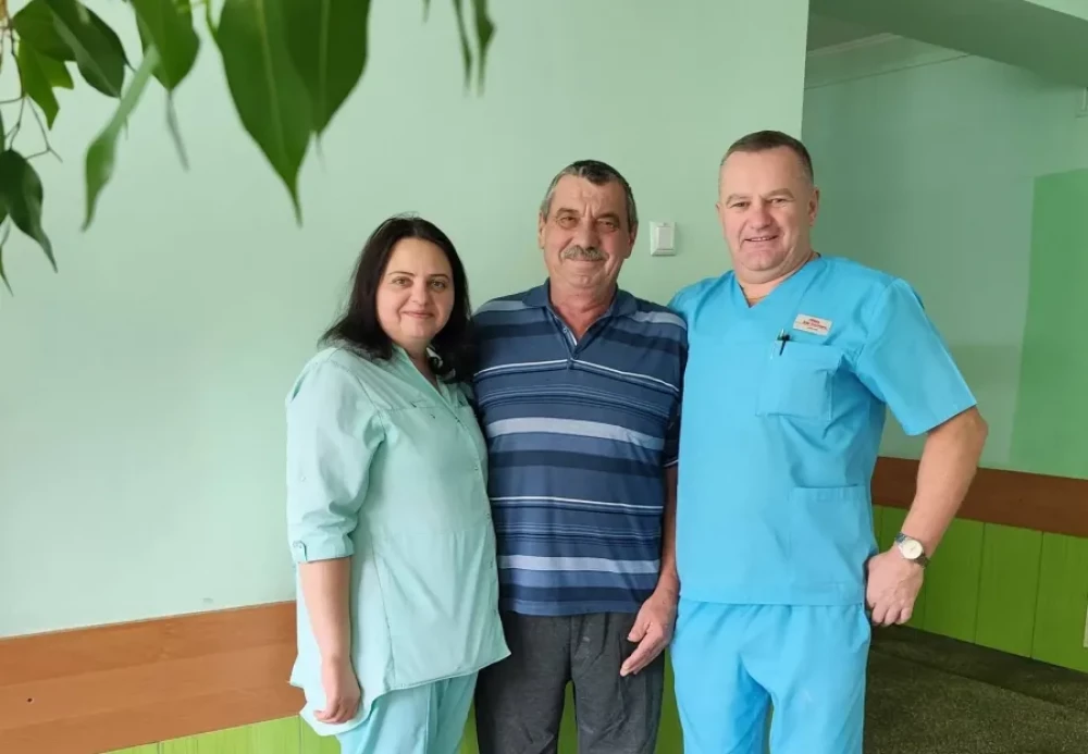 Двоє медиків позують із пацієнтом у лікарні