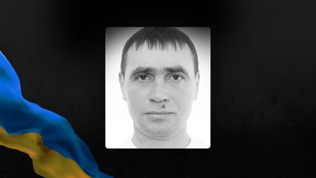 Чорно-білий портрет чоловіка на тлі українського прапора