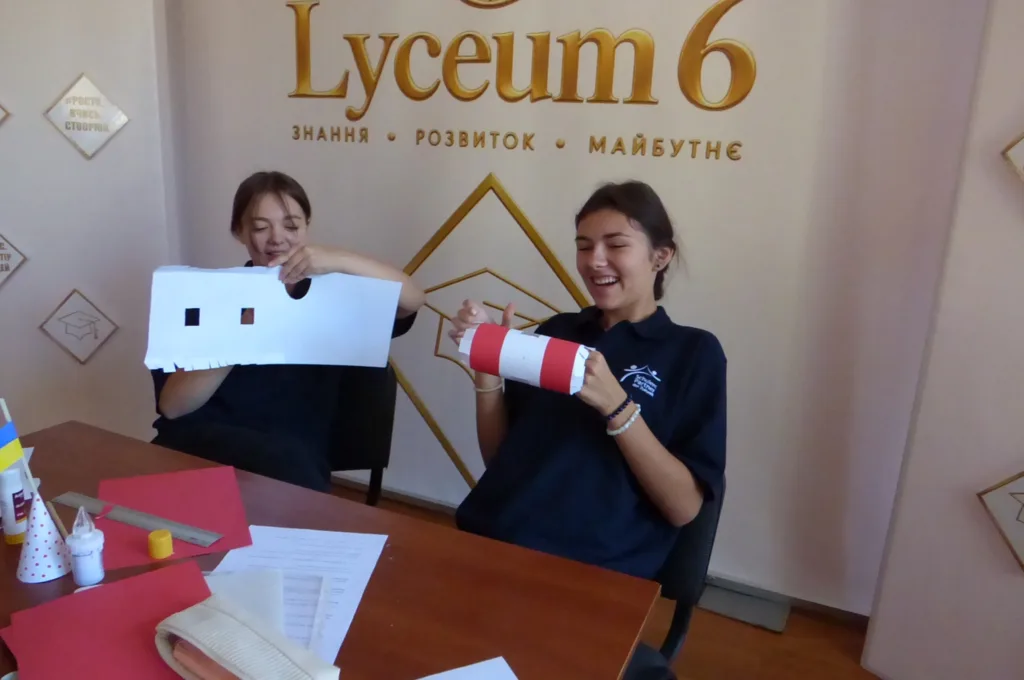 Дві учениці створюють паперові вироби в класі