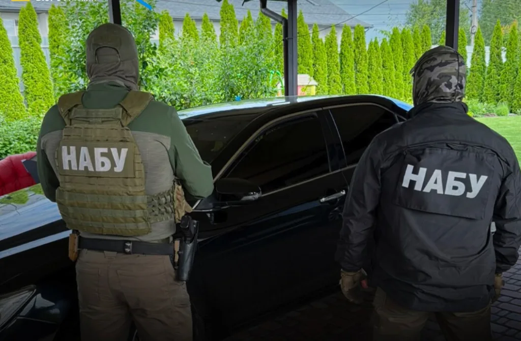Двоє співробітників НАБУ біля чорного автомобіля