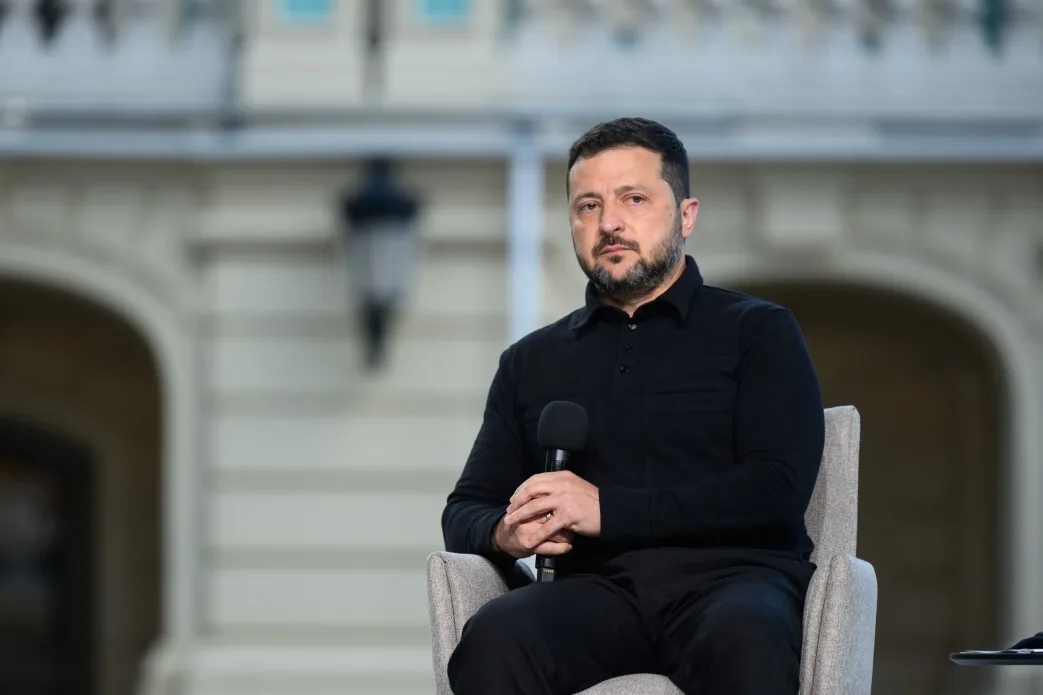 Володимир Зеленський сидить із мікрофоном під час заходу