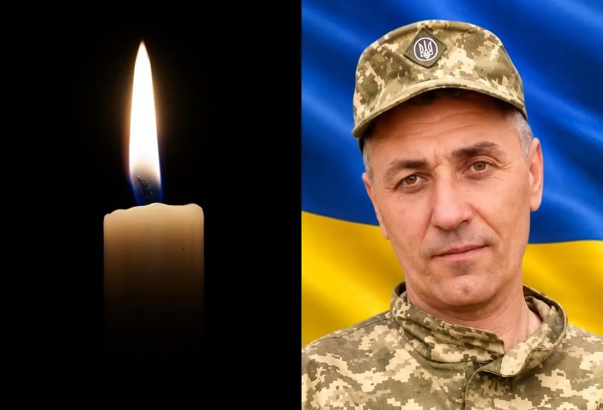 Запалена свічка поруч із портретом українського військового