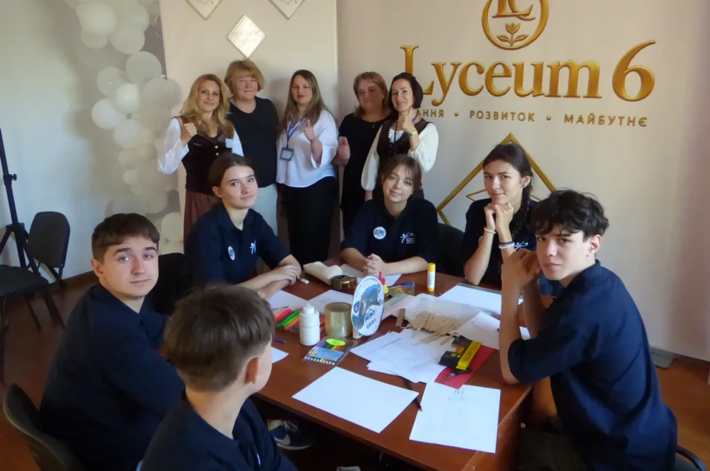 Учні й педагоги працюють за столом у Lyceum 6