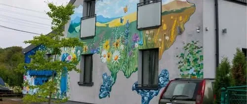 Мурал із квітами та горами на фасаді будинку