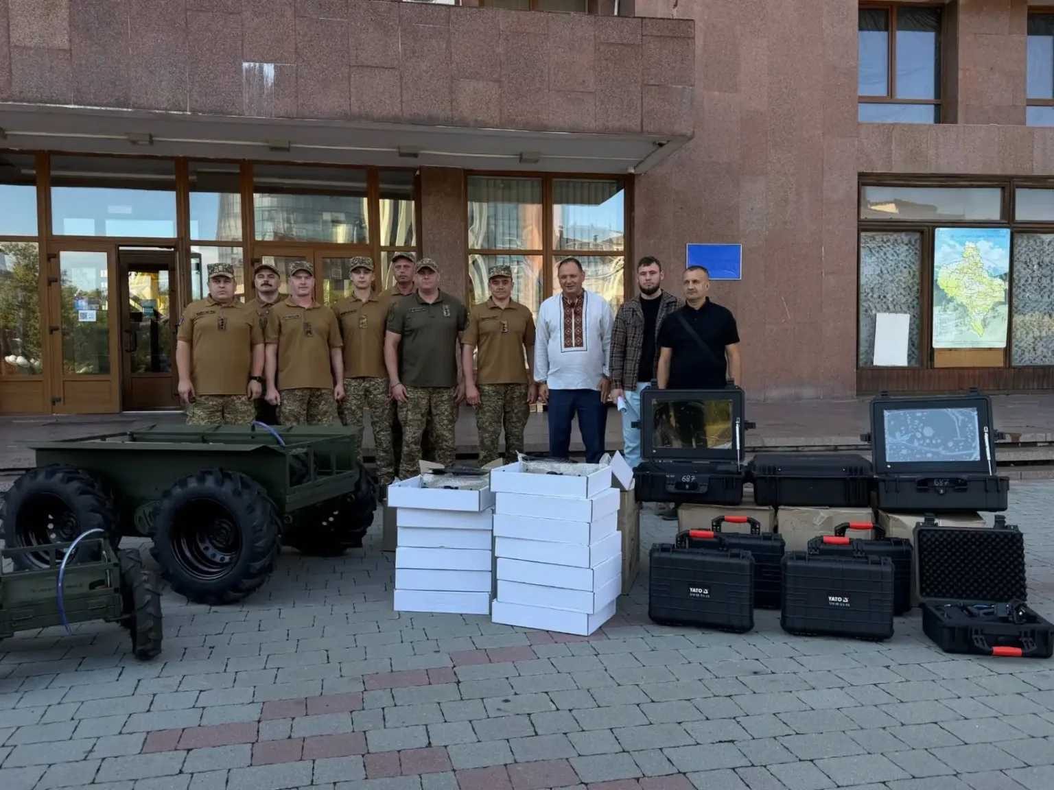 Військові та волонтери з обладнанням біля будівлі