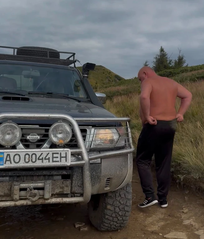Позашляховик Nissan і чоловік на гірській дорозі