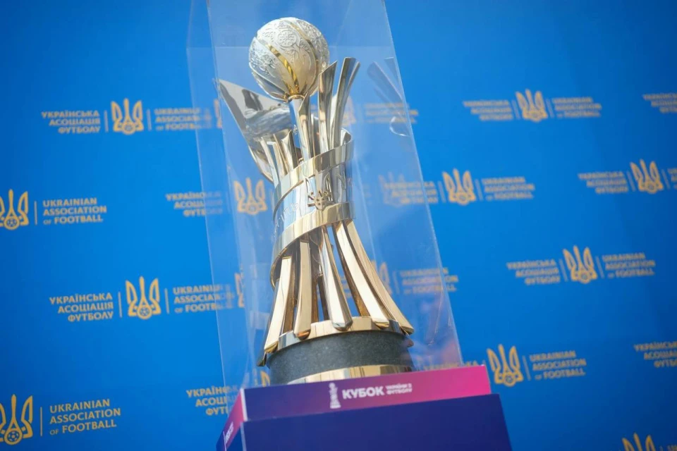 Футбольний кубок на тлі логотипів Української асоціації футболу