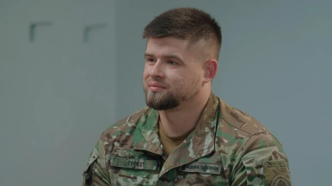 Військовий у камуфляжі сидить у приміщенні