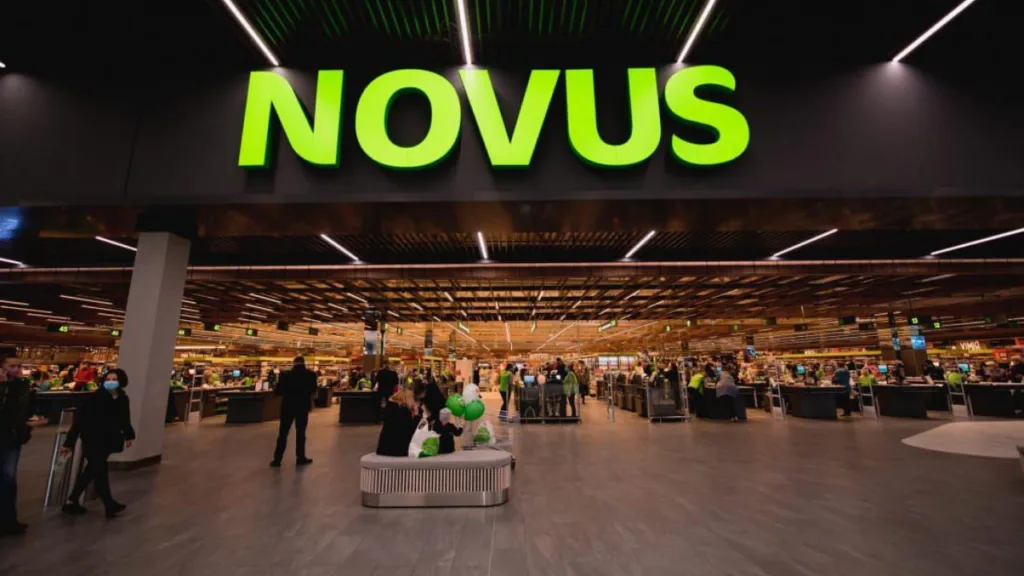 Вхід до супермаркету NOVUS із покупцями та касами